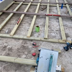 מסגרת עץ לבניית דק עם כלי עבודה שונים