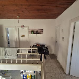 מסדרון עם דלתות לבנות ותקרה מעץ