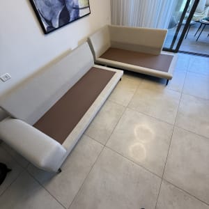 שתי ספות בהירות בחדר עם רצפת אריחים