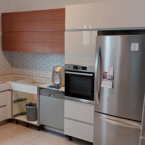 מטבח עם ארונות לבנים, מקרר נירוסטה ותנור בנוי