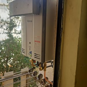 דוד גז מותקן על קיר חיצוני ליד חלון