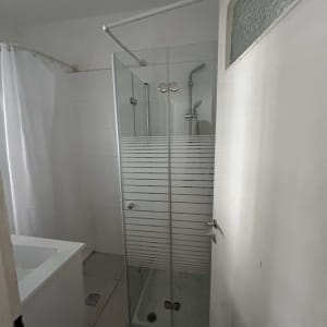 מקלחון זכוכית עם דלת פתוחה בחדר אמבטיה