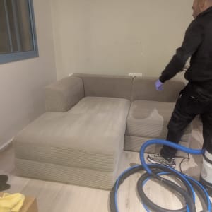 ניקוי ספה עם ציוד מקצועי ואדם בעבודה