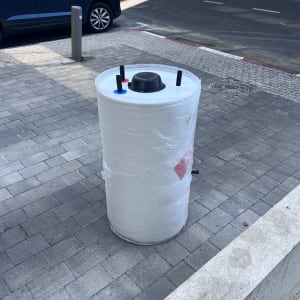 דוד שמש עטוף בניילון עם חיבורים על המדרכה