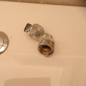 חלק צנרת ישן ומלוכלך על משטח לבן