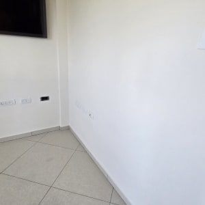 קיר צבוע עם טלוויזיה מותקנת ושקעים חשמליים