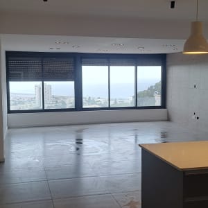 קיר צבוע בלבן בחדר ריק עם חלונות גדולים