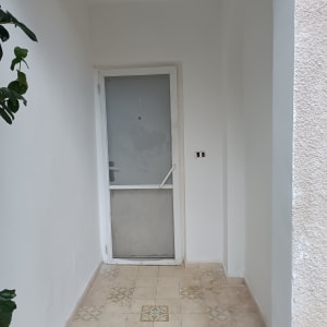 קיר ודלת צבועים בלבן עם רצפה מעוטרת