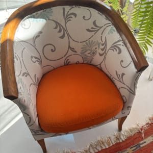 כיסא מרופד עם מושב כתום ודוגמת פרחים