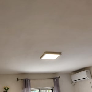 מנורת תקרה מרובעת דולקת בחדר עם מזגן