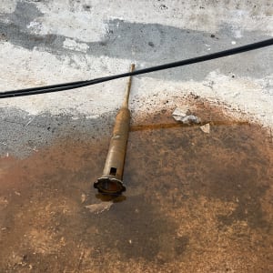 צינור חלוד על רצפה עם כבל חשמל שחור