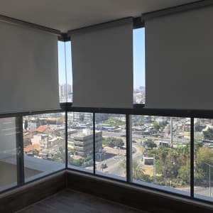 תריסים חשמליים בחלון פנורמי עם נוף עירוני