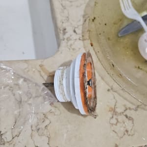 כיור עם חלקי צנרת וכלים מלוכלכים