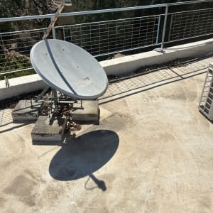 צלחת לוויין על גג עם מעקה מתכת