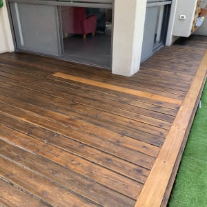 דק עץ חום ליד חלון זכוכית עם תריסים