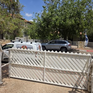 שער חשמלי לבן עם מנגנון פתיחה