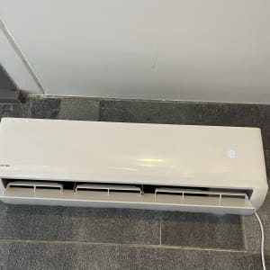 מזגן קיר לבן עם תצוגת טמפרטורה דיגיטלית