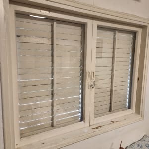 חלון עם תריסים לבנים בחדר פנימי