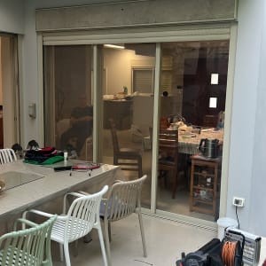 תריסים סגורים מעל דלת זכוכית גדולה במרפסת