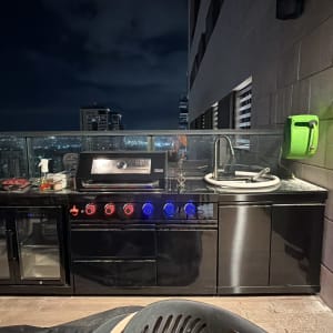 מטבח חוץ עם גריל וכיור על מרפסת בלילה