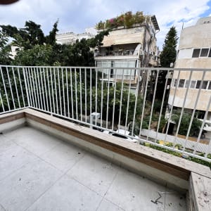 מעקה מתכת לבן בעיצוב נקי המותקן במרפסת דירה