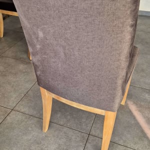 כיסא מרופד עם רגלי עץ על רצפת אריחים