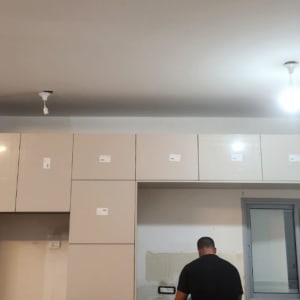 אדם עובד על התקנת ארונות במטבח