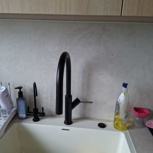 ברז שחור בכיור מטבח עם כלים וסבון כלים