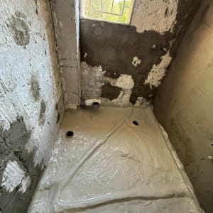 שיפוץ חדר אמבטיה עם קירות בטון ורצפה חדשה