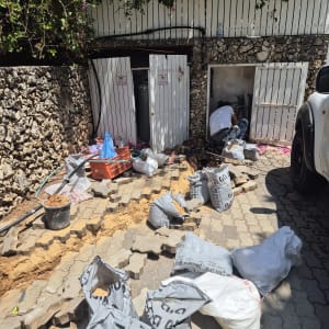 אדם עובד על צנרת ליד דלתות פתוחות