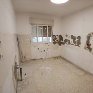 חדר ריק עם קירות מתוקנים ושאריות צבע