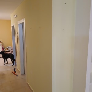 קיר צבוע בצבע צהוב עם מטאטא ברקע