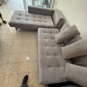 ספות אפורות בחדר עם רצפת קרמיקה