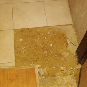 רצפה עם אריחים שבורים ועבודת תיקון