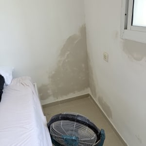 קיר עם תיקוני צבע ומאוורר בחדר שינה