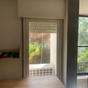 חלון זכוכית עם נוף חיצוני ועץ ירוק