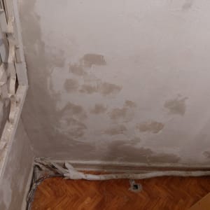 קיר עם סימני רטיבות ותיקונים בצבע