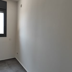 קיר צבוע בלבן עם חלון בצד שמאל