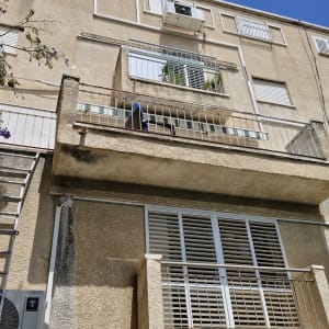 סולם צמוד לקיר בניין עם סימני צבע