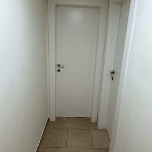 דלתות לבנות עם ידיות מתכת במסדרון צר