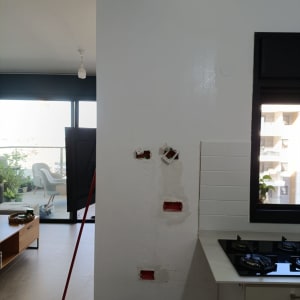 קיר צבוע עם תיקונים ליד חלון ומטבח