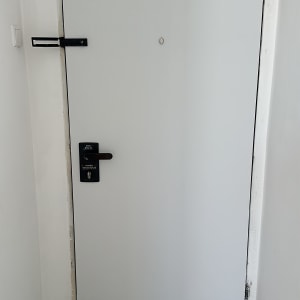 דלת מצופה בצבע לבן עם מנעול שחור