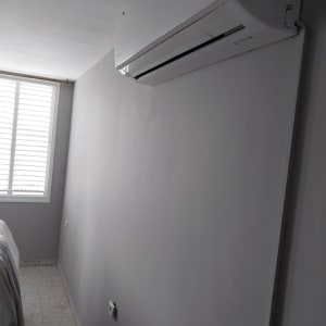 קיר צבוע בצבע אפור בהיר ליד מזגן