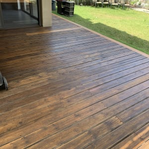 דק עץ חום בגינה עם דשא ירוק