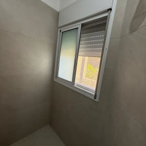 חלון עם תריסים בחדר עם קירות אריחים