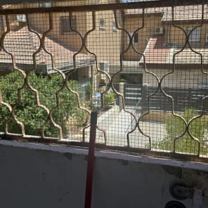 מקל לניקוי ליד חלון עם סורגים