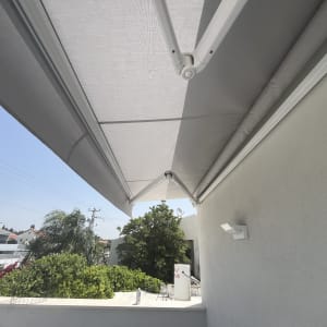 סוכך בד אפור מותקן על קיר חיצוני