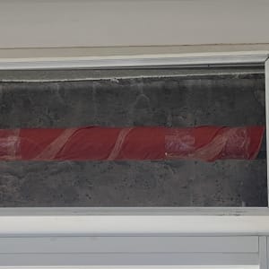 צינור עטוף בניילון אדום בתוך מסגרת חלון