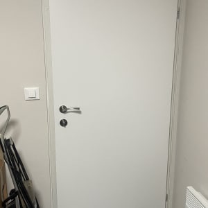 דלת לבנה עם ידית מתכת ומנעול