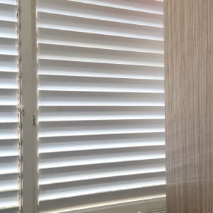 תריסים לבנים עם וילון ובד אדום